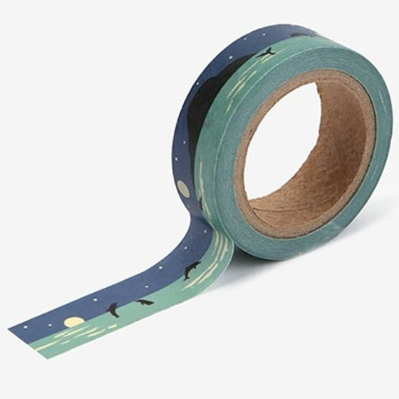 A roll of Daily Like washi tape, featuring an ocean landscape with dolphins and a full moon