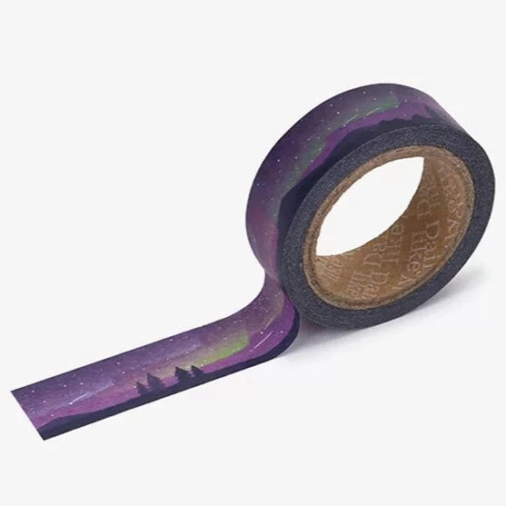 A roll of Daily Like washi tape, featuring a forest landscape at night with shooting stars and the aurora borealis in the sky