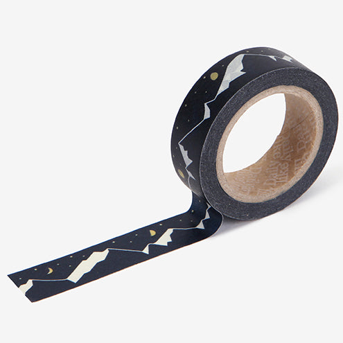A roll of Daily Like washi tape, featuring a mountain landscape and sky on a black background