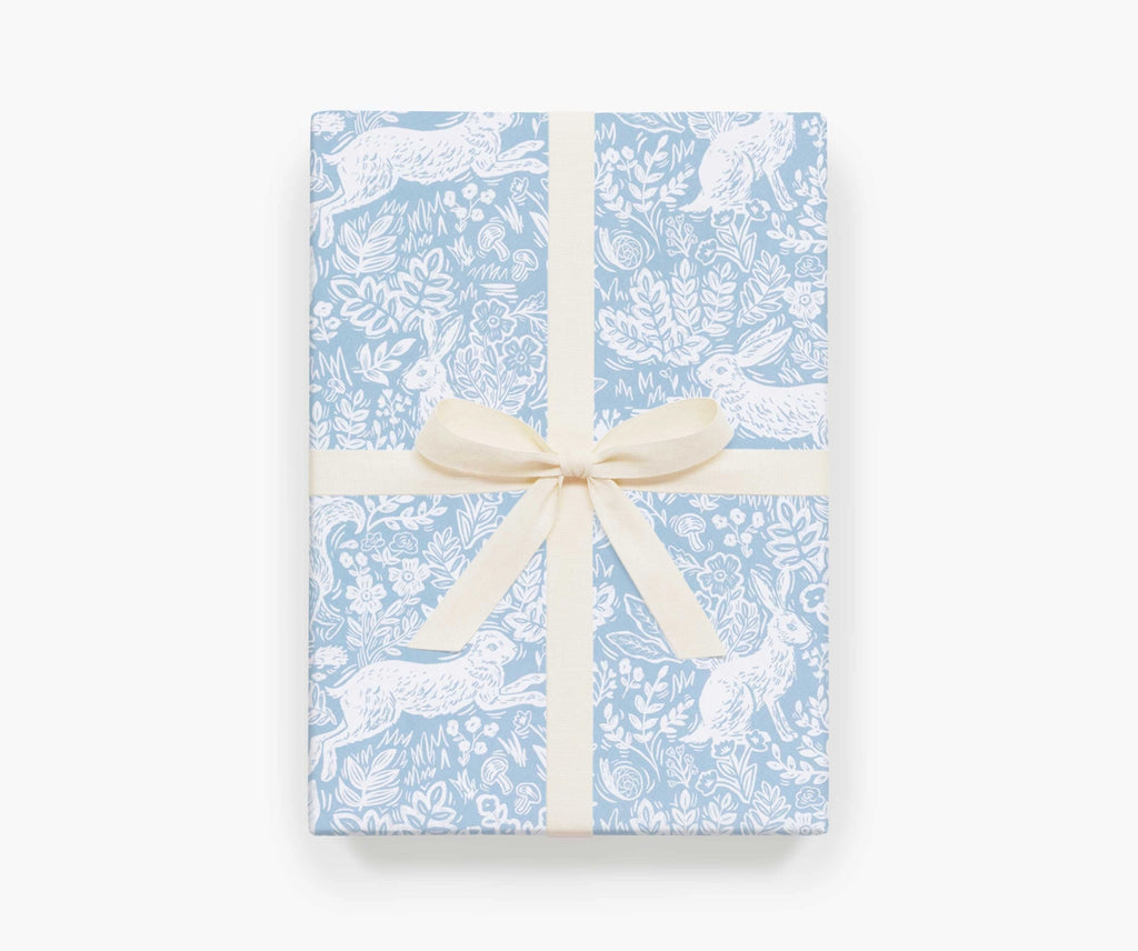 A present wrapped in Fable sheet wrap by Rifle Paper Co, and tied with a cream ribbon.