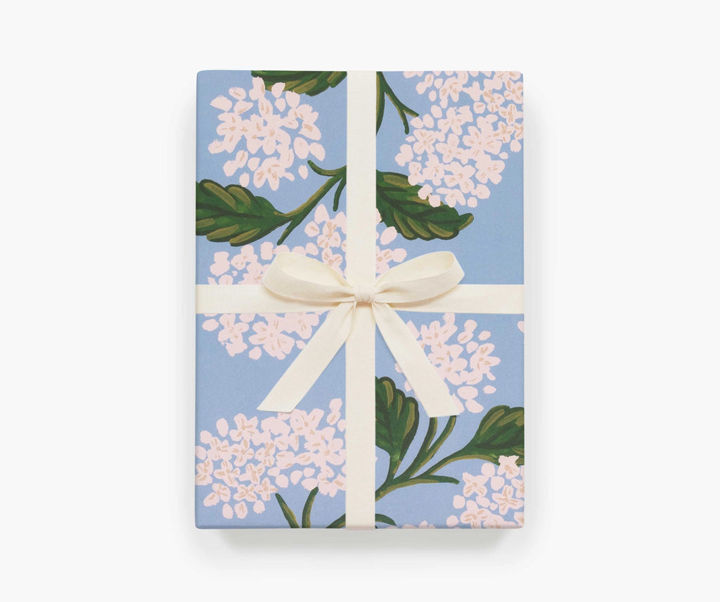 A present wrapped in Hydrangea sheet wrap by Rifle Paper Co, tied with a white ribbon