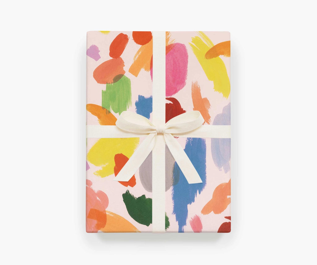A present wrapped with the Palette sheet wrap by Rifle Paper Co, with a white ribbon tied around it.