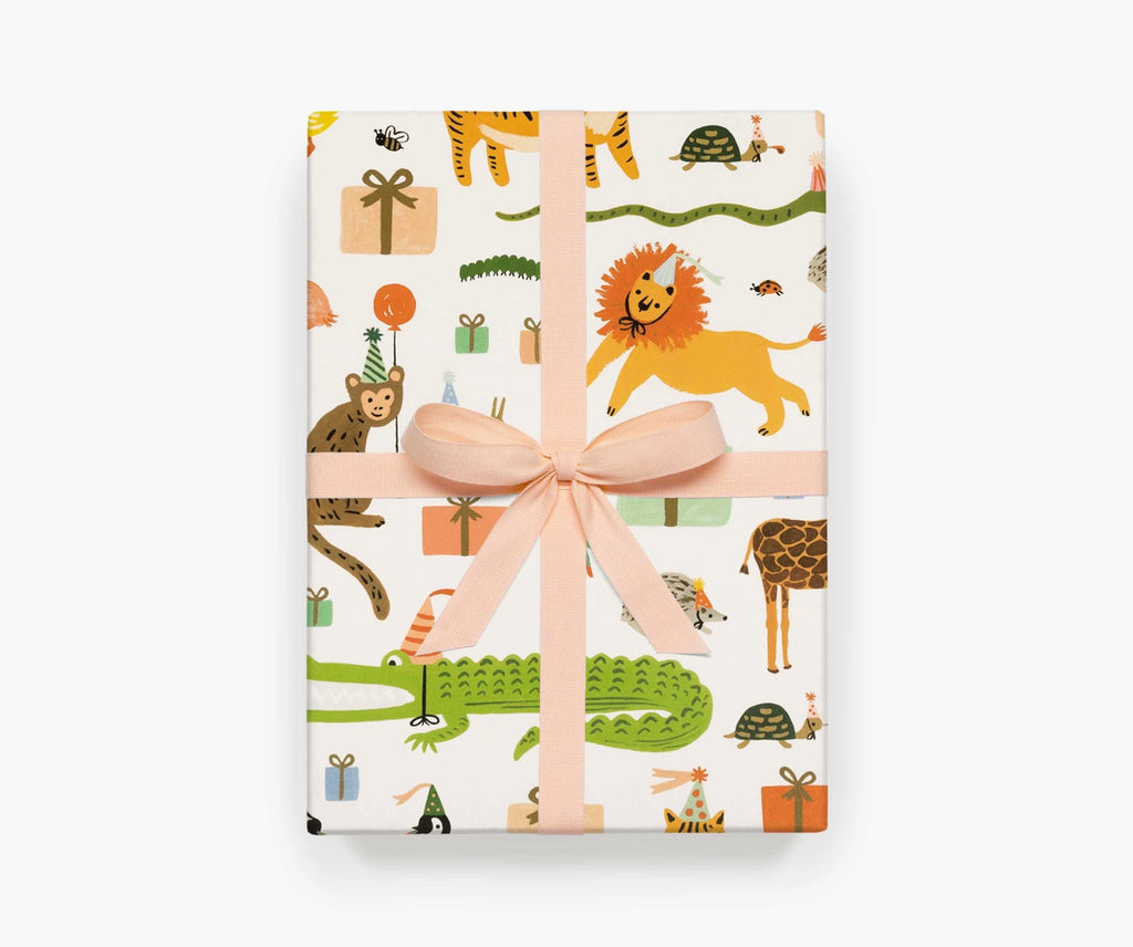 A present wrapped in Party Animals sheet wrap, tied with a soft peach ribbon